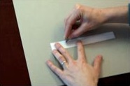 2. Desdobla la tira que vayas a usar en la parte inferior de la obra. Corta medias lunas a un lado del doblez en intervalos de 5 cm.